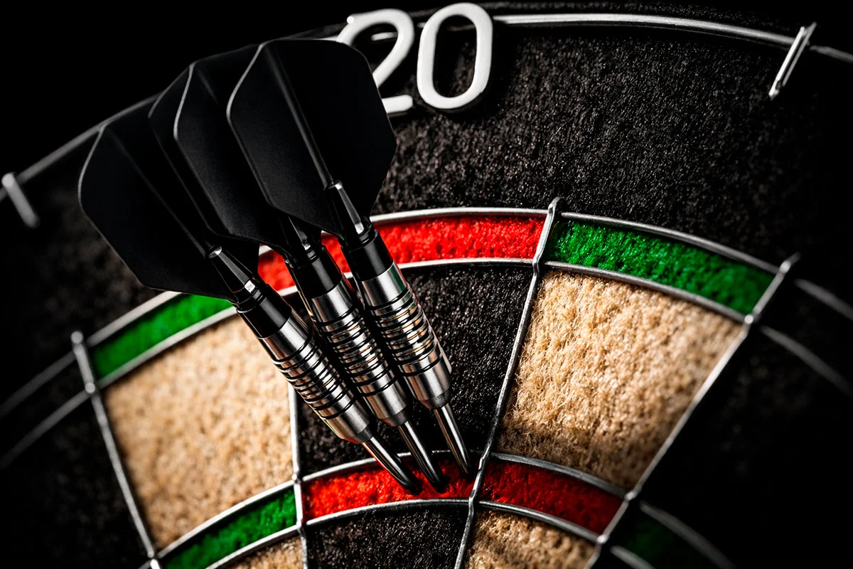 Nahaufnahme von drei Darts-Pfeilen in der Triple-20 auf einer Dartscheibe